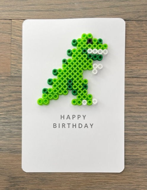 Picture of a Happy Birthday card with a green dinosaur on it