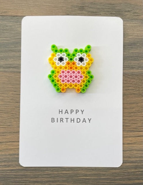 Picture of a Happy Birthday card with a lime green, yellow, pink owl on it