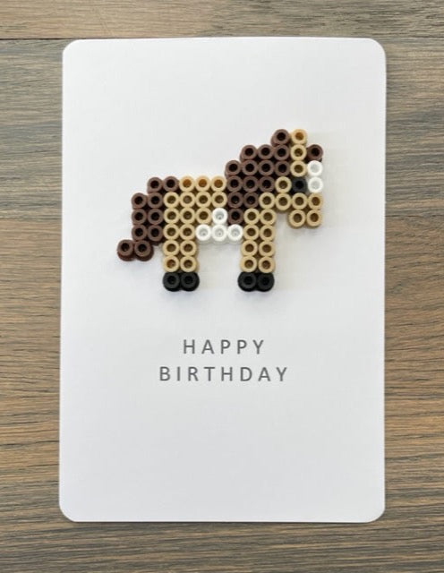 Picture of a Happy Birthday card with a cute, tan and dark brown pony on it