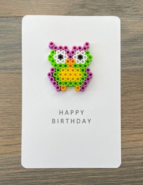 Picture of a Happy Birthday card with a purple, lime green , yellow owl on it