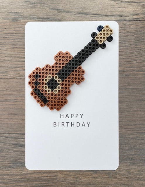 Picture of a Happy Birthday card with a light brown guitar on it