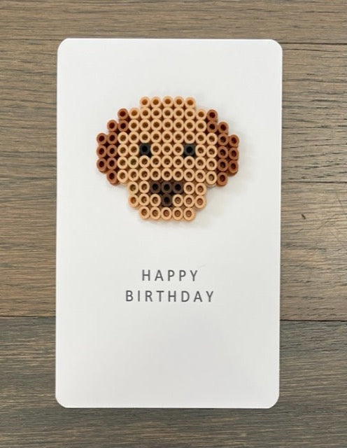 Picture of dog face that is light brown with dark brown ears on a Happy Birthday card.